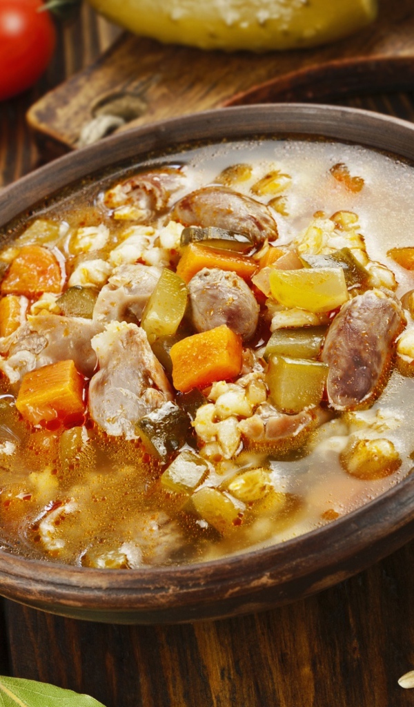 Перловый суп с сердечками на столе с помидорами 