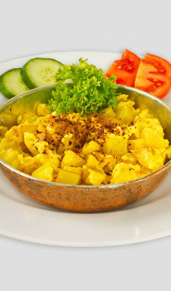 Картофель с овощами на белой тарелке