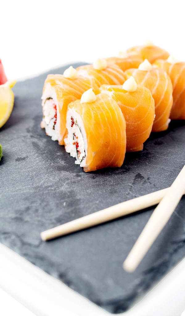 Роллы с красной рыбой на тарелке с палочками