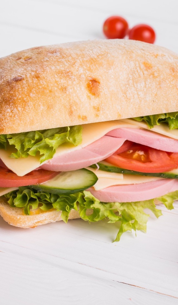 Сендвич с соусом и помидорами на столе 