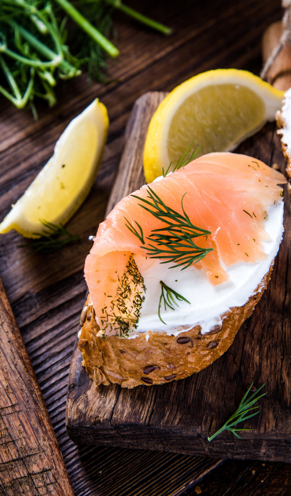 Бутерброды с сыром и красной рыбой на разделочной доске