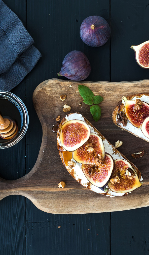 Бутерброды с инжиром на разделочной доске с медом 