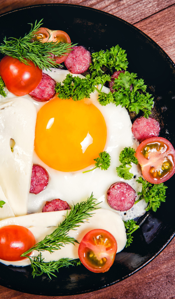 Яичница с колбасой, сыром,  помидорами и зеленью на сковороде