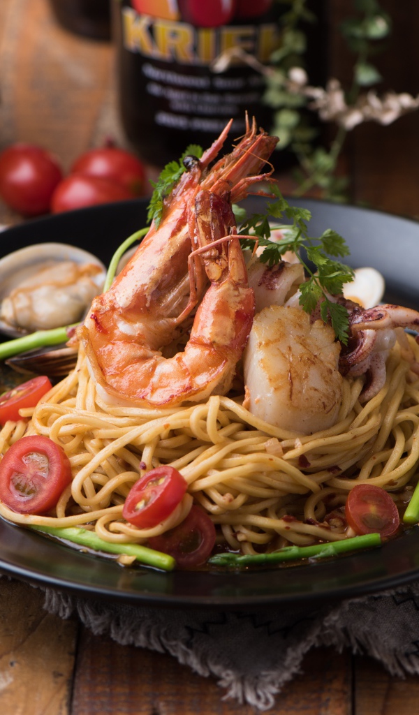 Спагетти с морепродуктами на черной тарелке