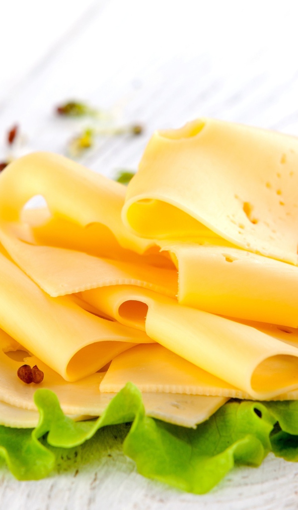 Тонко нарезанный сыр с листом салата и помидором