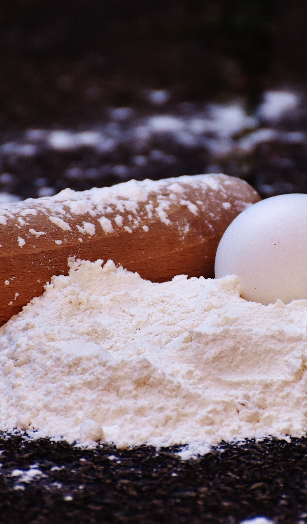 Два яйца, мука и скалка на столе