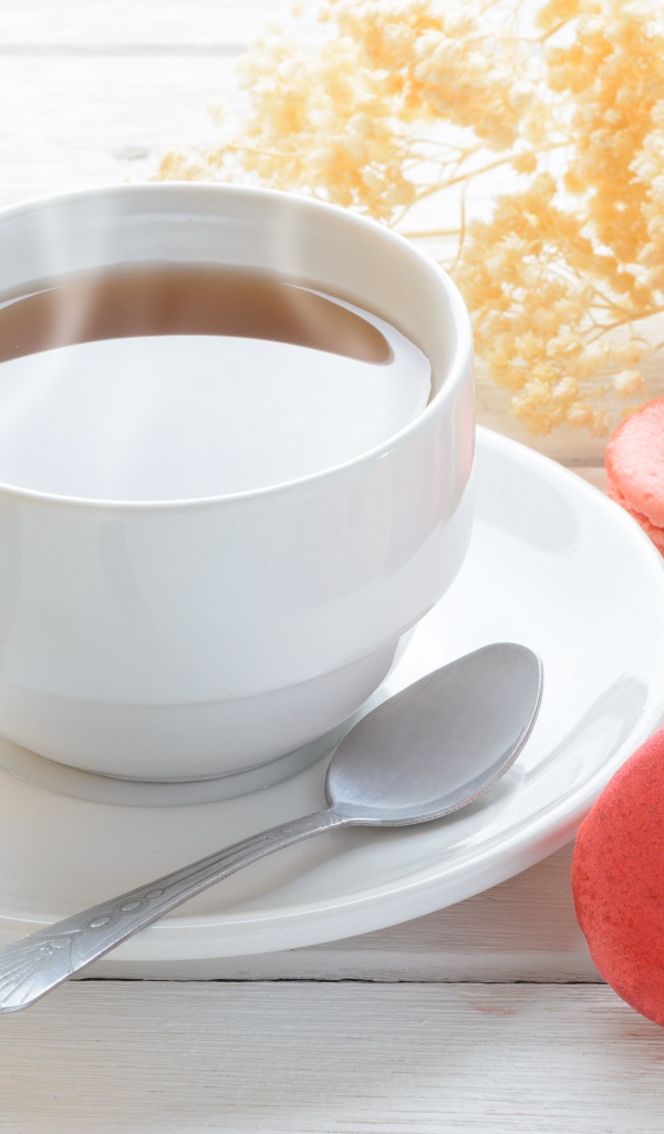 Белая чашка чая с макарунами