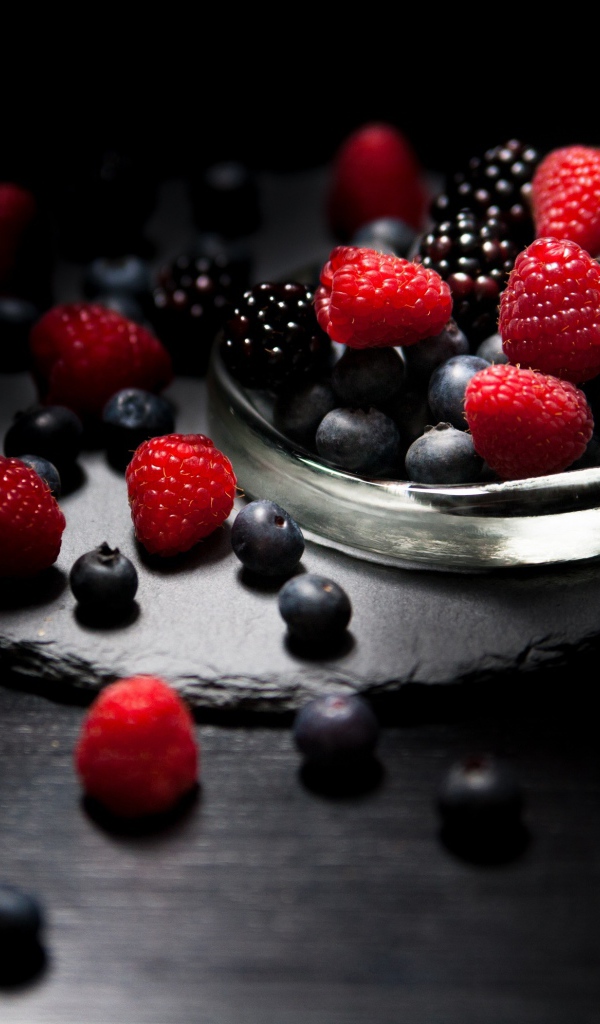 Ягоды черники, малины и ежевики на черном фоне