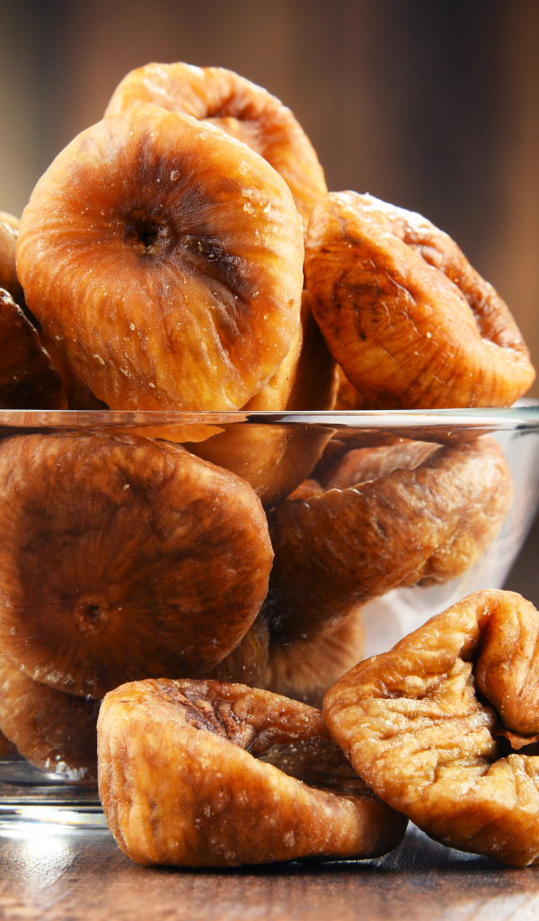 Инжир в стеклянной вазе на столе 