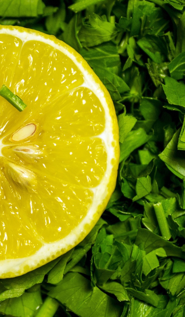Половина желтого лимона с нарезанной зеленью петрушки 