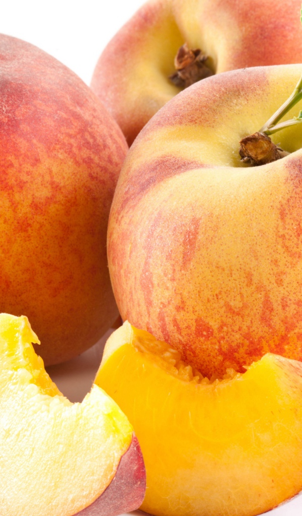 Крупные спелые сладкие персики на белом фоне