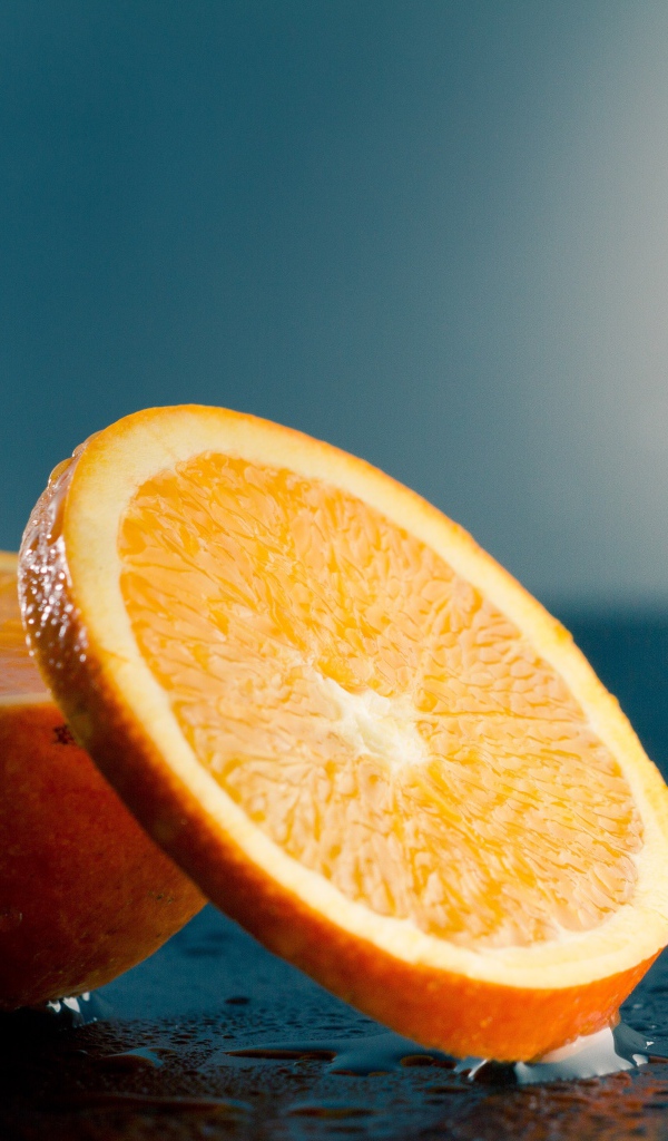 Оранжевый апельсин на мокром столе