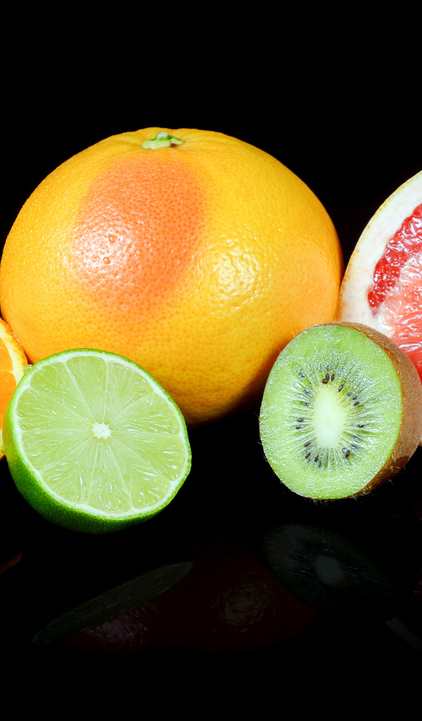 Апельсины, грейпфруты,  лайм и киви на черном фоне