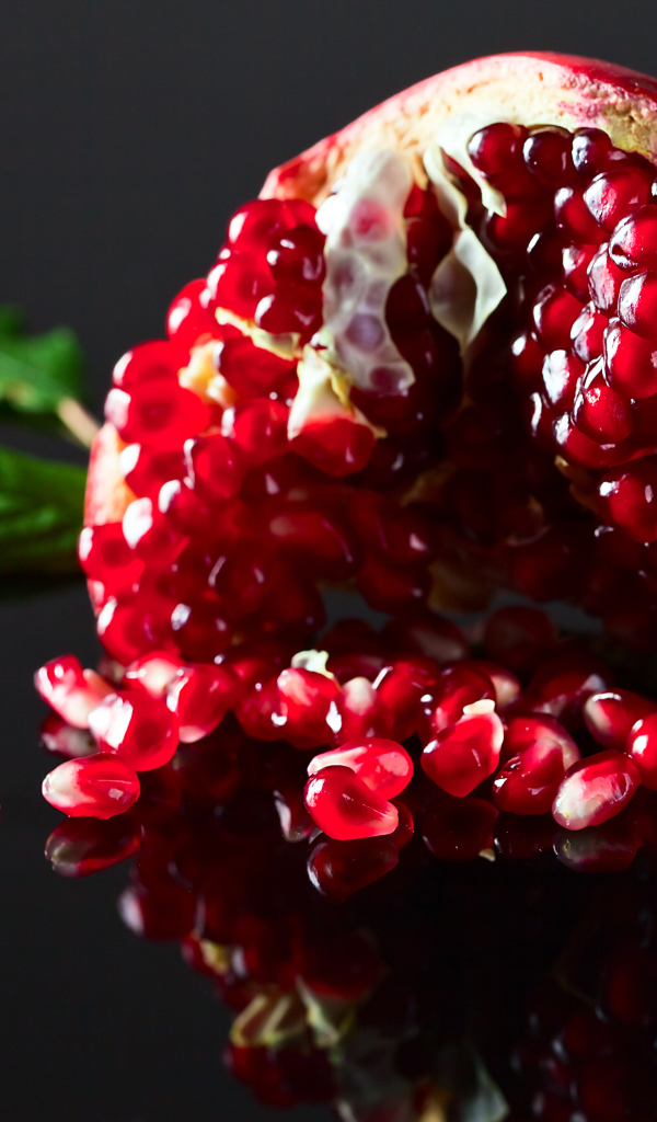 Чищенный гранат на сером фоне крупным планом