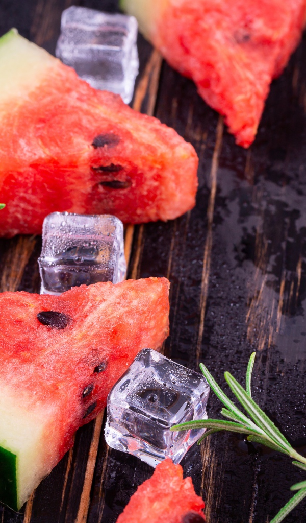 Кусочки арбуза на столе со льдом и розмарином