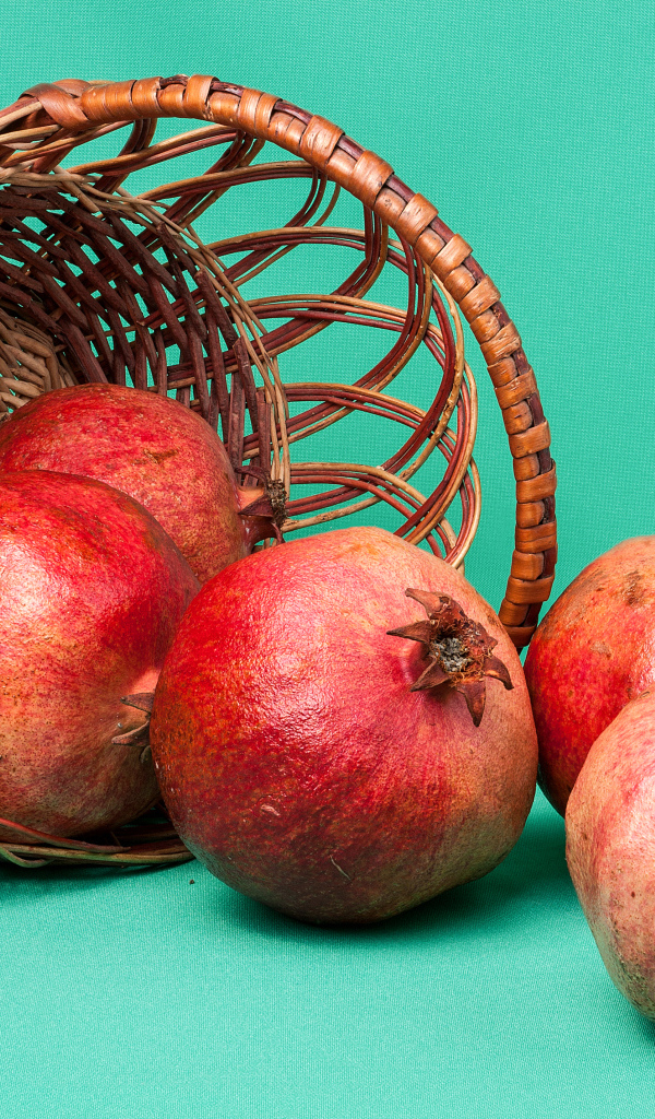 Плоды граната в корзине на голубом фоне