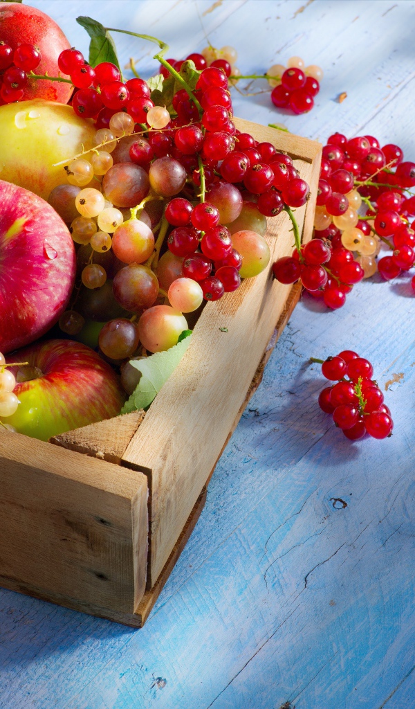 Спелые сочные ягоды и фрукты на столе в деревянном ящике