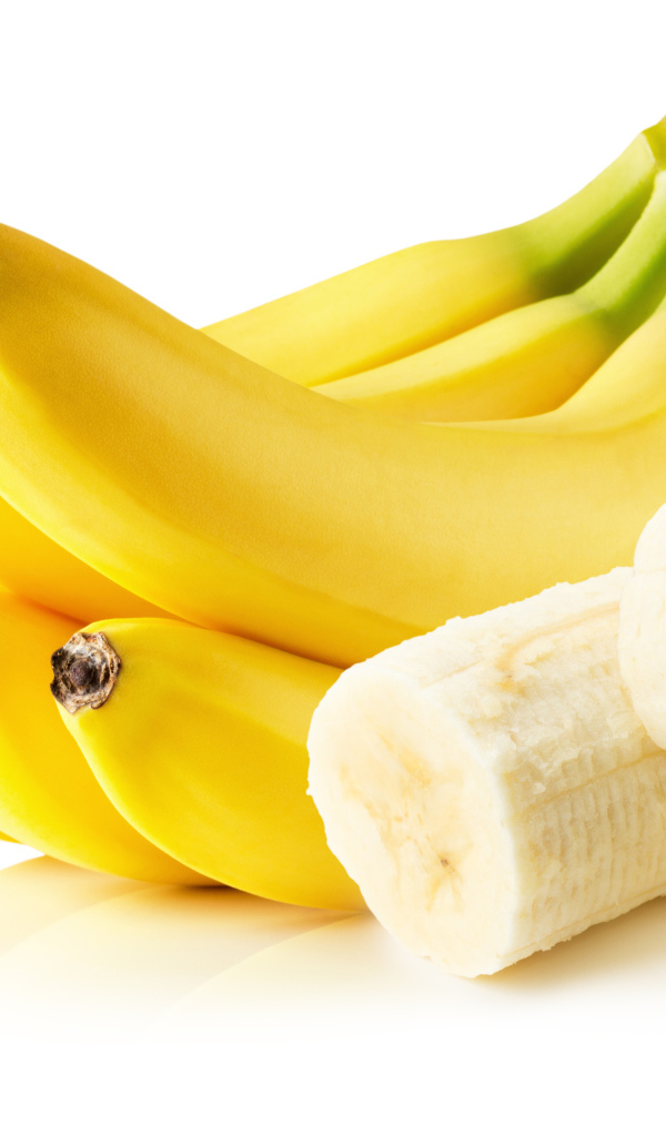 Спелые желтые бананы на белом фоне