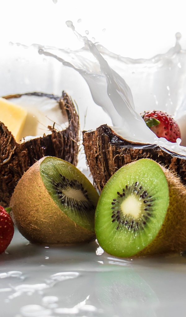 Тропические фрукты кокосы, ананасы и киви на белом фоне с клубникой