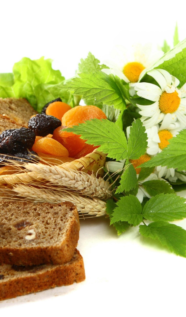 Сухофрукты с хлебом и цветами ромашки на белом фоне