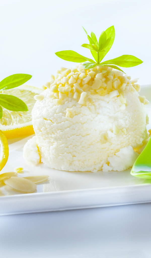 Шарик лимонного мороженого с фисташками с зеленой ложкой