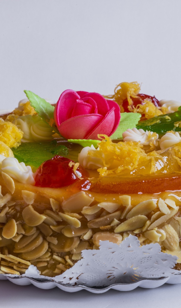 Красивый торт с кремом и ягодами украшен розовым цветком