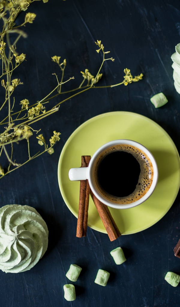 Чашка кофе с меренгой и шоколадом на столе