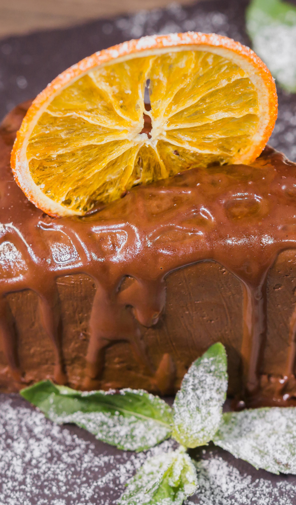 Кусок пирожного с шоколадом и кусочком апельсина