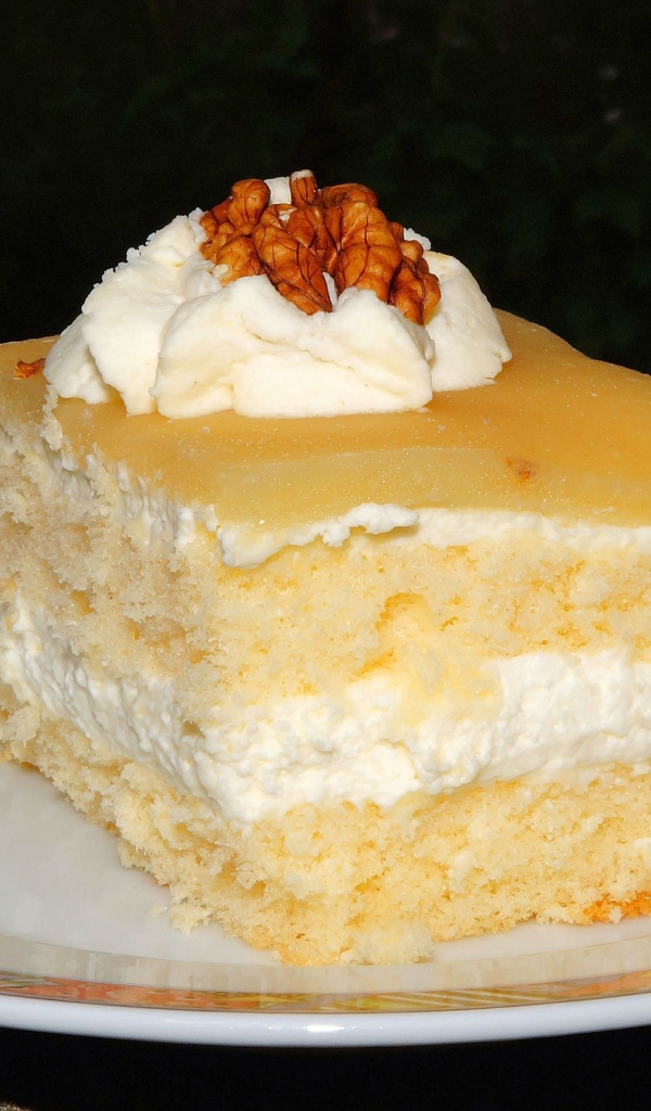Кусок торта со сливочным кремом и грецкими орехами