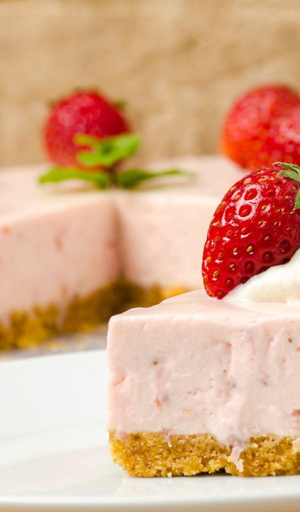 Кусок торта с клубникой на белой тарелке