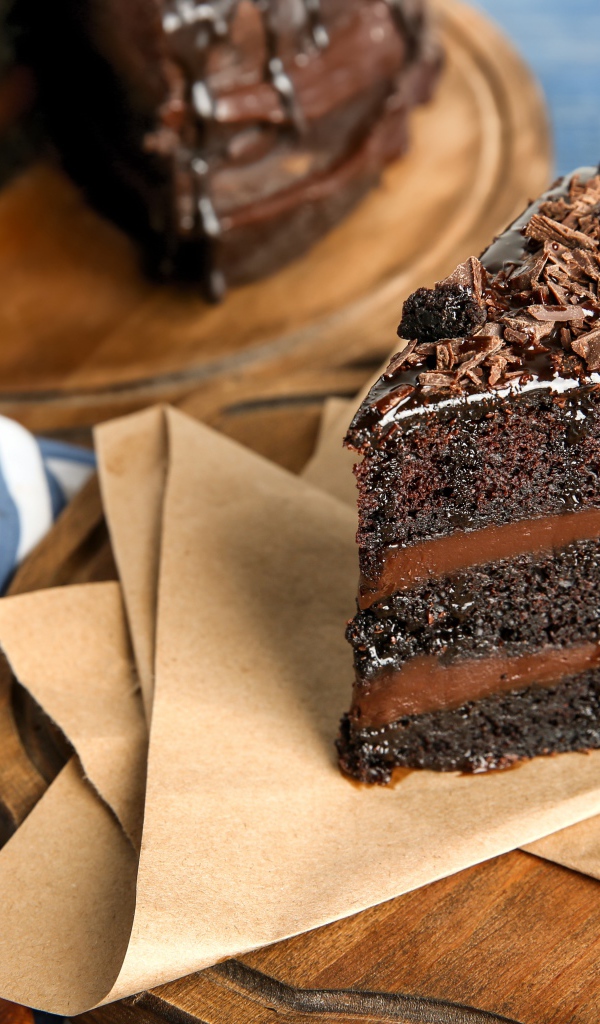 Кусок вкусного шоколадного торта на столе с кофейными зернами