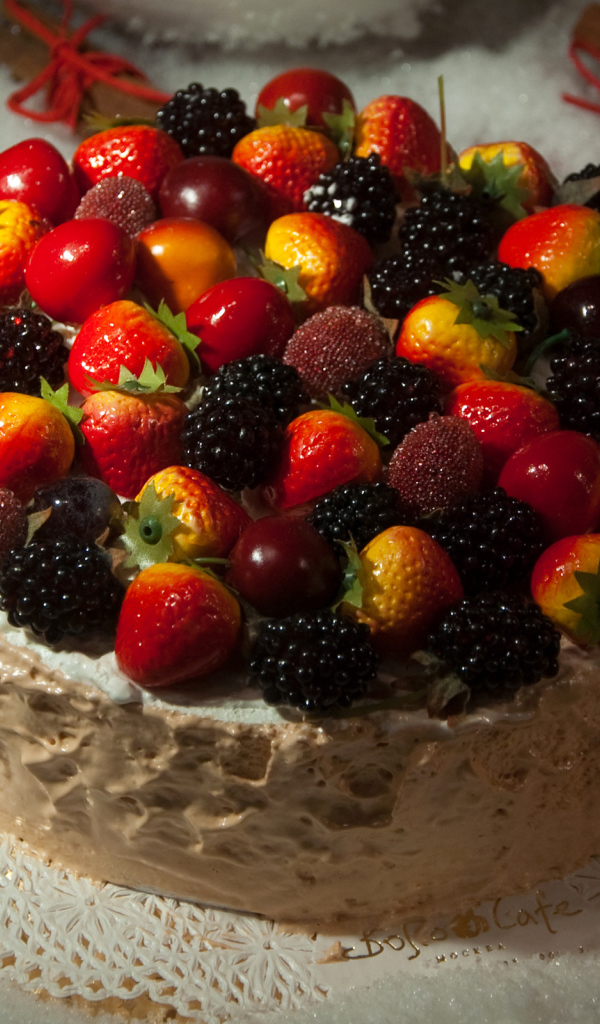 Аппетитный торт с ягодами на столе 