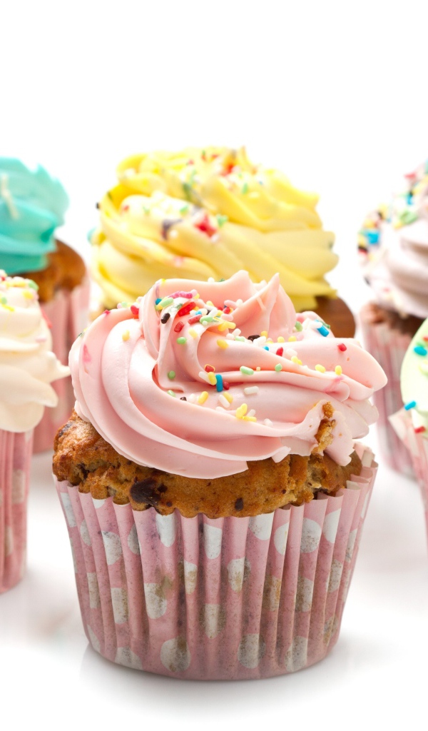 Аппетитные капкейки с кремом на белом фоне