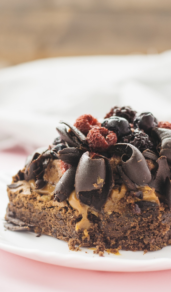 Аппетитный шоколадный десерт брауни с ягодами 