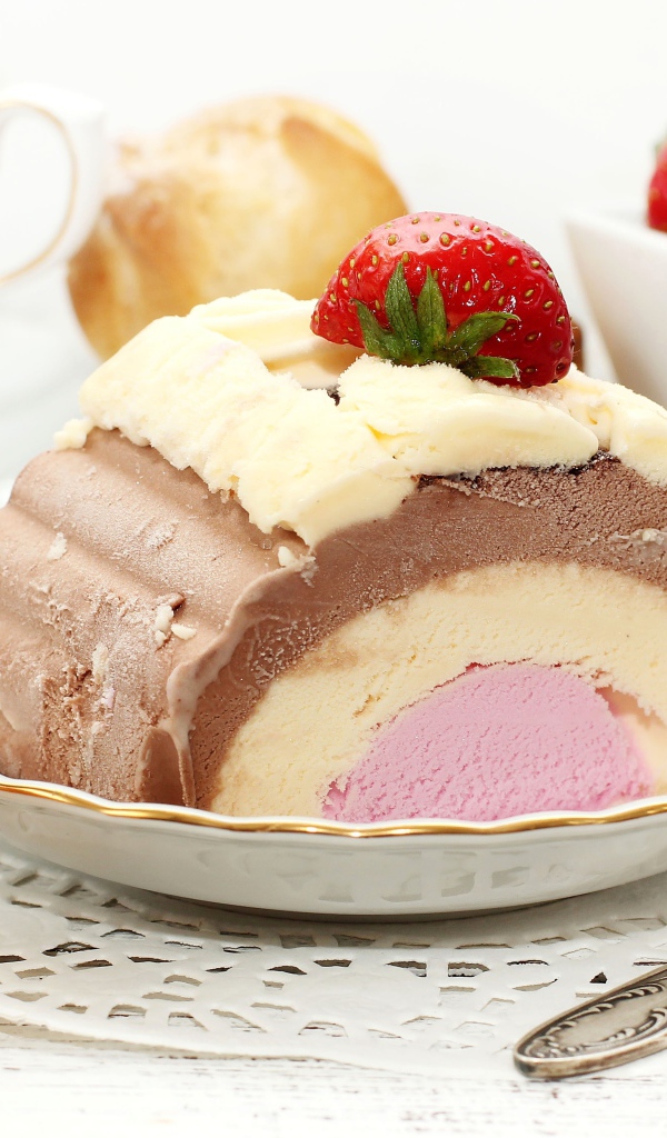Аппетитное мороженое на столе с эклером и ягодами клубники 