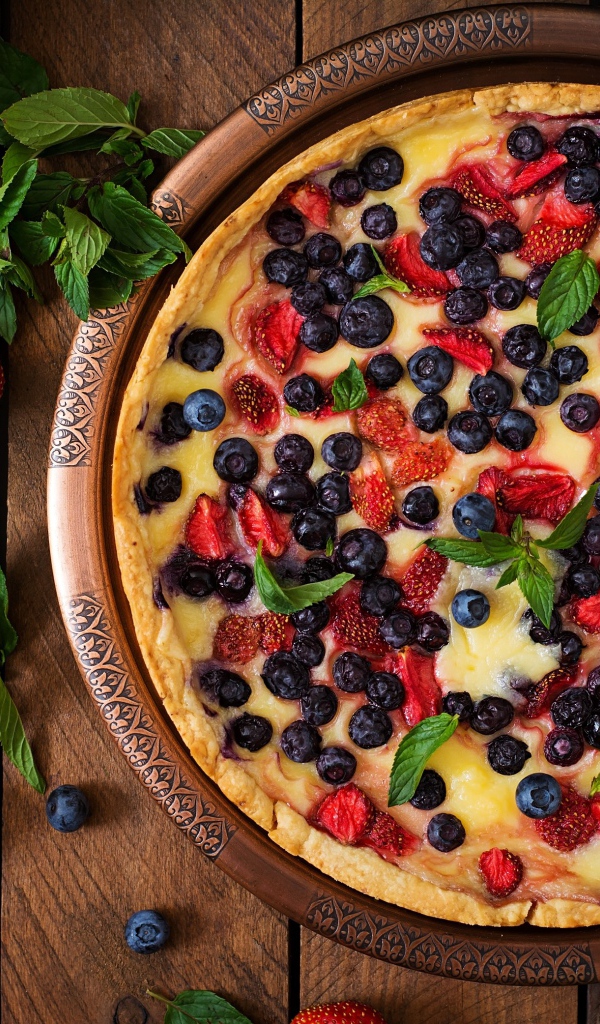 Аппетитный пирог с ягодами на деревянном столе