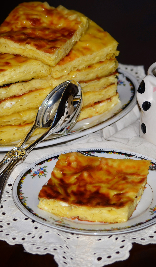 Аппетитный сладкий пирог с чашкой чая на столе