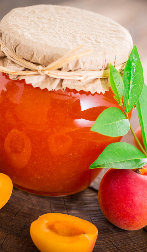 Абрикосовое варенье в банке на столе с абрикосами