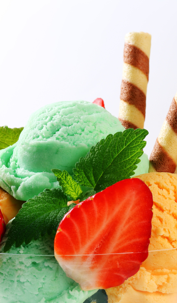 Шарики разноцветного мороженого с клубникой и трубочками