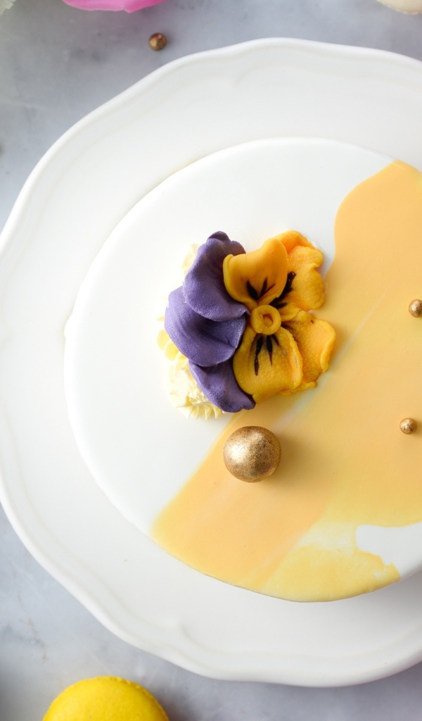 Красивый торт на белой тарелке с цветами вид сверху 