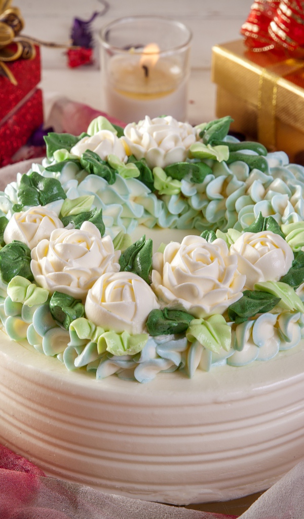 Красивый праздничный торт на столе с подарками и свечами