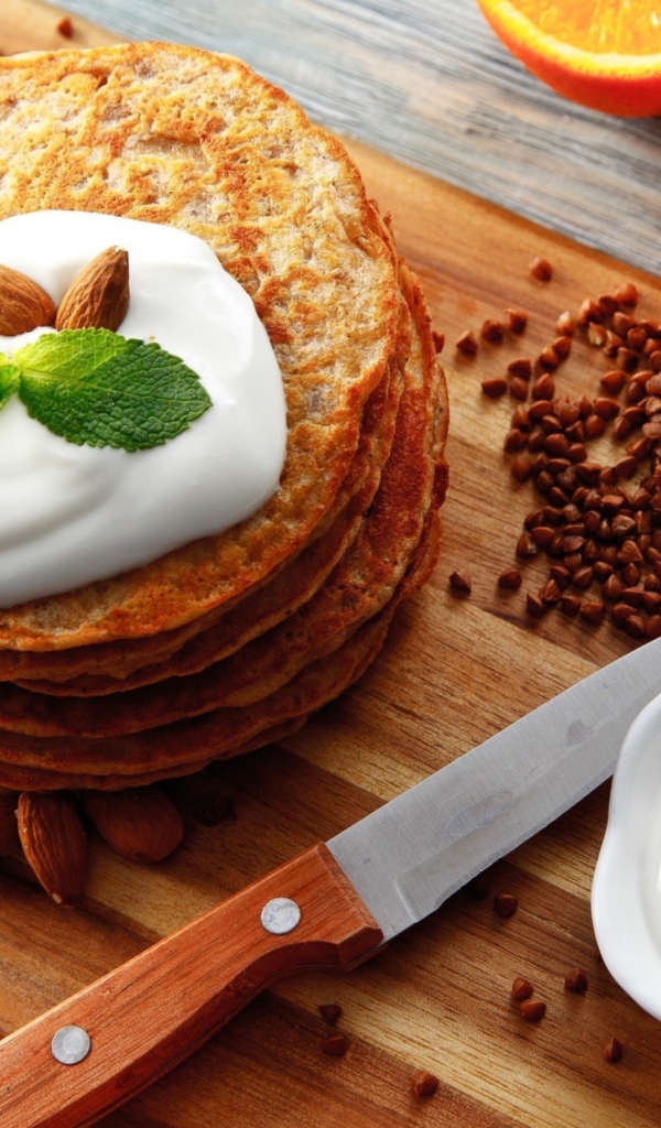 Гречневые оладьи со сметаной на разделочной доске