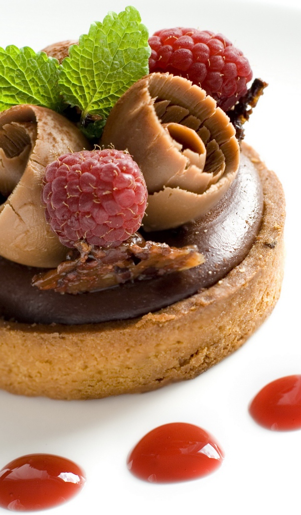 Пирожное с шоколадом и ягодами малины на белом фоне