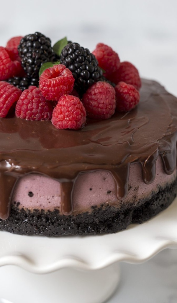 Торт с шоколадом на столе с ягодами черники и малины 