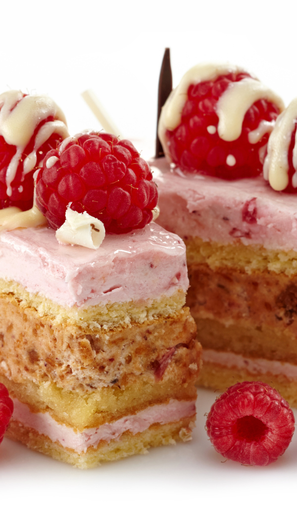 Пирожные с ягодами малины на белом фоне