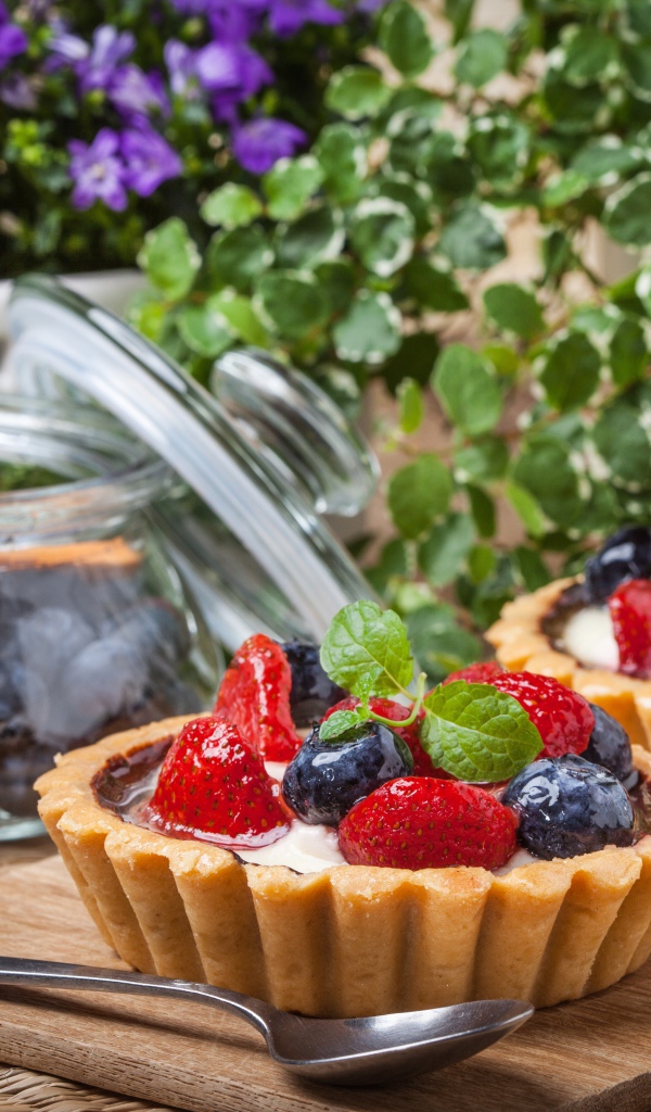 Пирожные с ягодами клубники и черники на столе