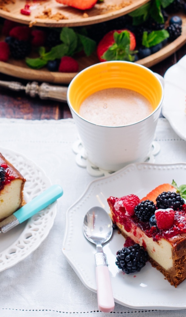 Чизкейк с ягодами на столе с кофе 