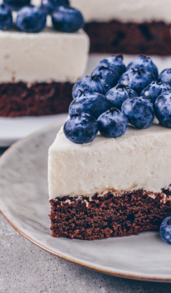 Чизкейк с ягодами черники на тарелке