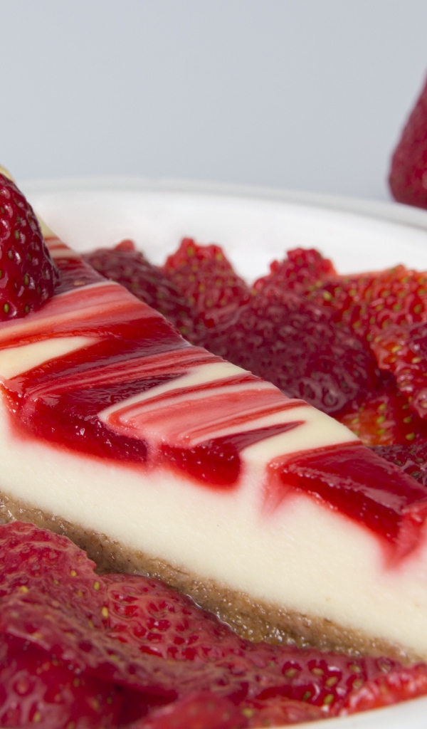 Чизкейк с ягодами клубники в белой тарелке 