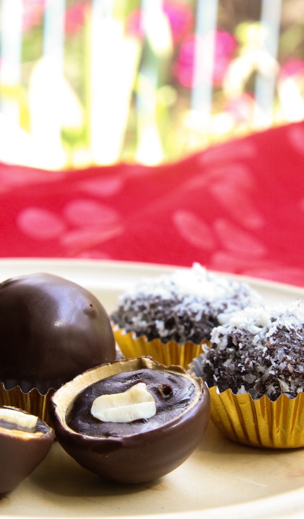 Шоколадные круглые конфеты на белой тарелке 